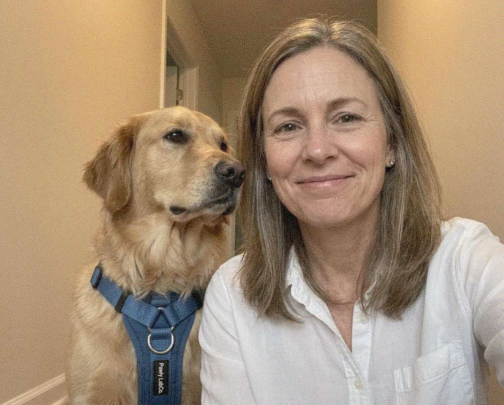 Denise taking a selfie with her golden retriever wearing the blue Pawly no-pull harness
